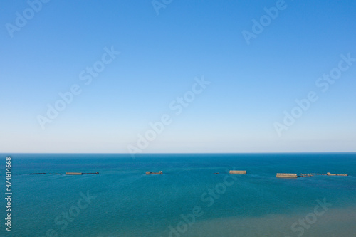 The artificial port of Gold beach in Asnelles in the middle of the English Channel in Europe, France, Normandy, Arromanches les Bains, in summer, on a sunny day. © Florent
