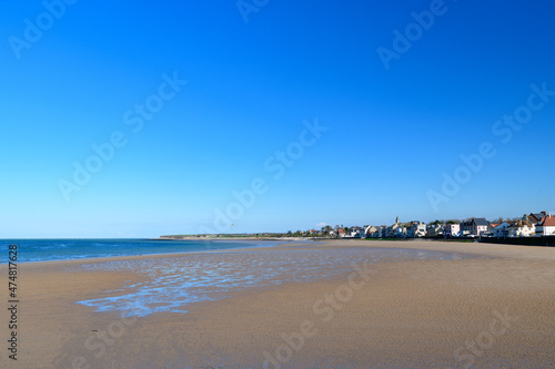 The fine sand beach of the city of Grandcamp-Maisy in Europe, France, Normandy, towards Omaha beach, in spring, on a sunny day.