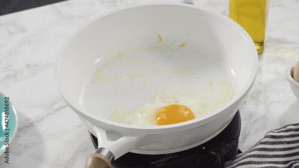 Close up view. Frying farm fresh eggs in a white skillet. Close up view. Frying farm fresh eggs in a white skillet.