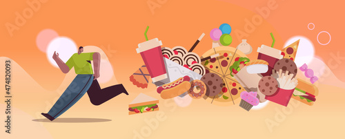 man running away from junk food assortment of fast food unhealthy nutrition junkfood addiction concept