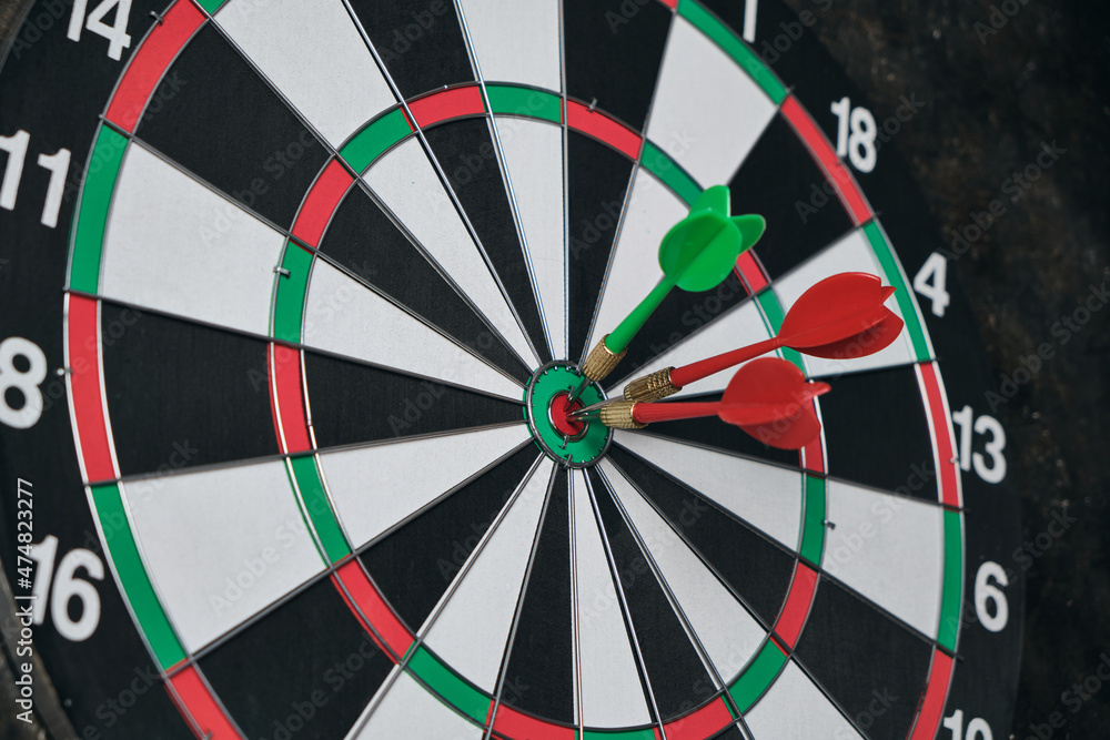 Dartboard with darts hitting exactly on target. Dartboard with darts hitting exactly on target.