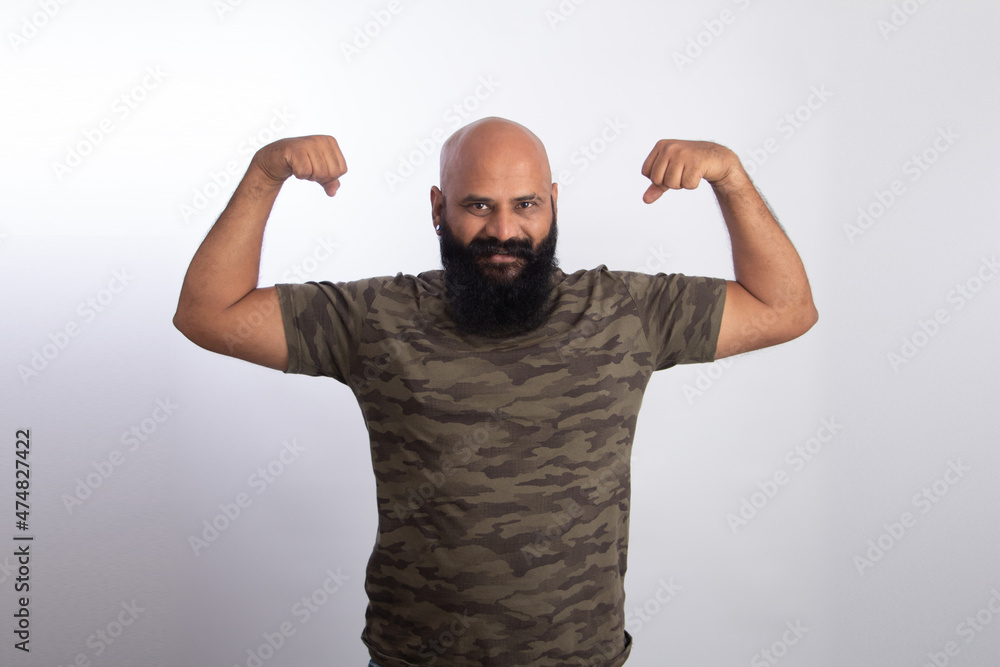 Naklejka premium happy Indian Healthy middle aged man showing his arms and biceps