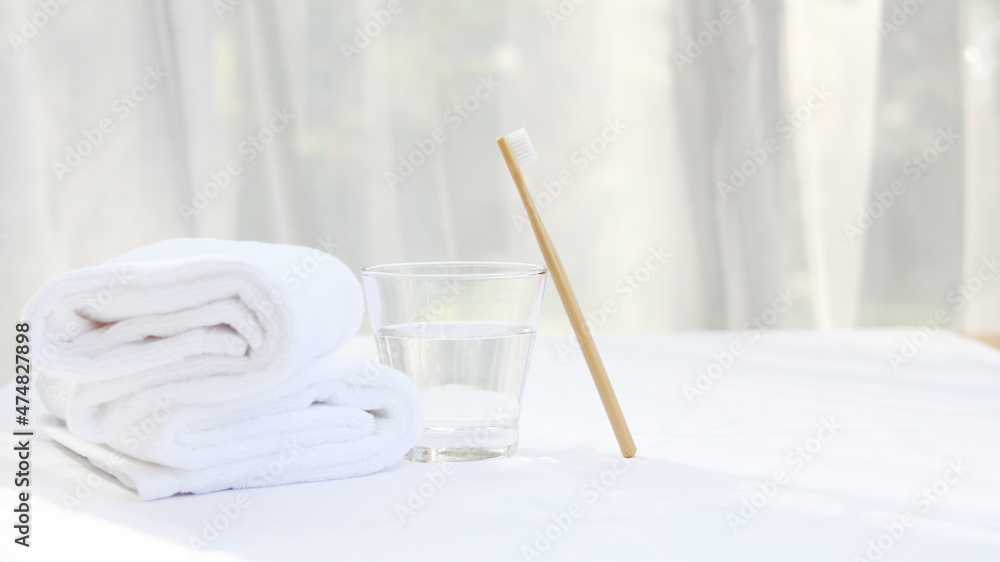 Toothbrush, toothpaste and towel and healthcare concept, glass of water, white a cotton towel and powder