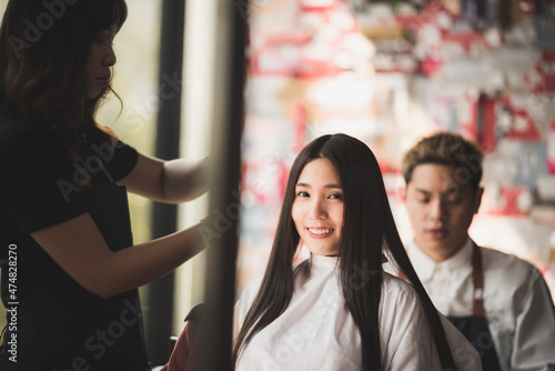 young woman hairdresser in salon, hair care beauty fashion with female girl