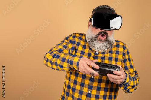 Bearded hipster man wears a head-mounted display, games, excitement, surprised. © jcalvera