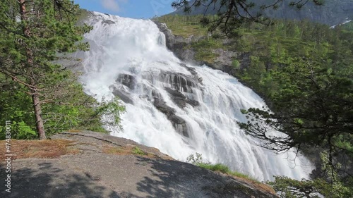 Voss, Hordaland, Norway. Waterfall Tvindefossen In Spring. Waterfall Tvindefossen Is Largest And Highest Waterfall Of Norway. Famous Natural Norwegian Landmark And Popular Destination. Woman Tourust photo