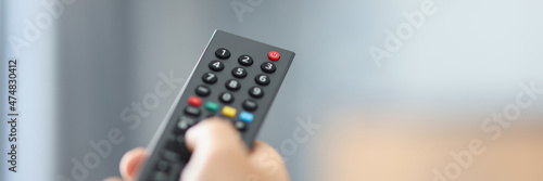 Watching TV and using the remote control closeup