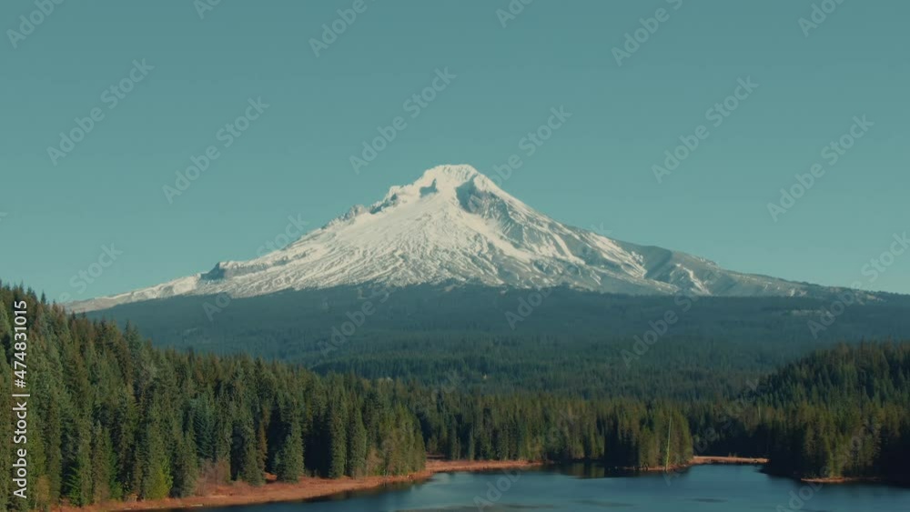 4k aerial snowy mountain with lake and evergreen hills in foreground drone dolly out 4k aerial snowy mountain with lake and evergreen hills in foreground drone dolly out