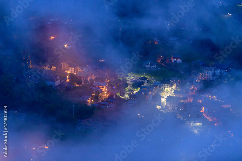 The city center of Les Houches in the clouds in the Mont Blanc massif in Europe, France, the Alps, towards Chamonix, in summer, at night.