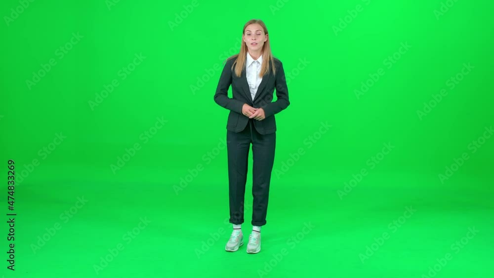 Female news reporter stands and speaks on a green background, looks into the camera, template for TV news agencies, woman journalist at work, chromakey. Female news reporter stands and speaks on a green background, looks into the camera, template for TV news agencies, woman journalist at work, chromakey.