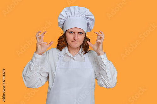 Angry female chef with emotions on her face on a studio background, mockup copy space
