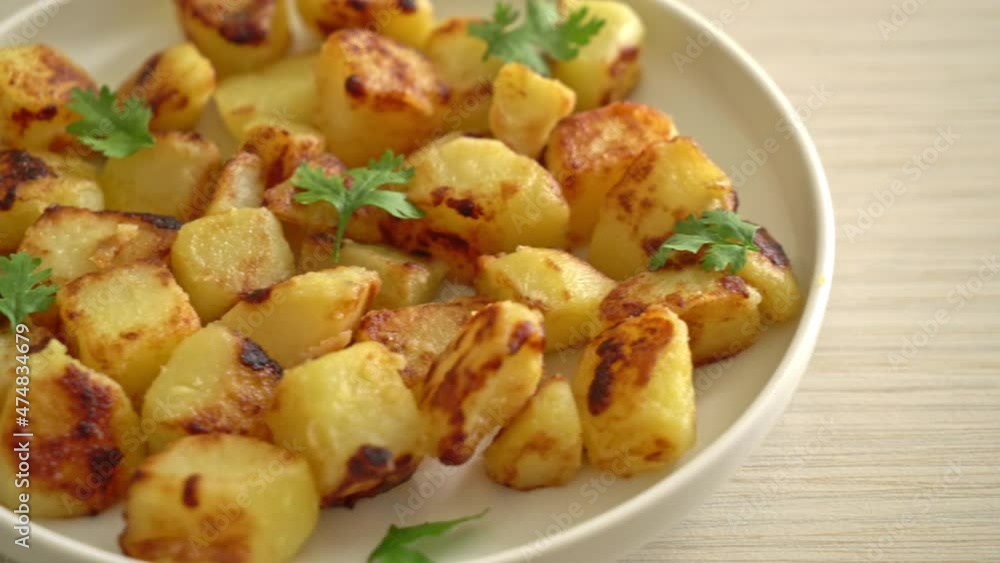 Roasted or grilled potatoes on white plate Roasted or grilled potatoes on white plate