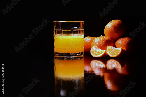 Mandarynki i pomarańcze jako sok. Orzeźwiająca moc owoców w szklance. Świeżość, witaminy, piękno, moda, wegetarianizm. pasja w samo zdrowiu owoców. Zielone życie, namiętne chwile. © fotolowkey