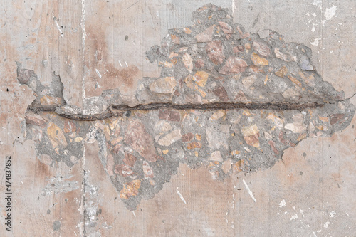 Textured grunge background. An old wall with a peeling cover and a deep pattern. Beige pink background