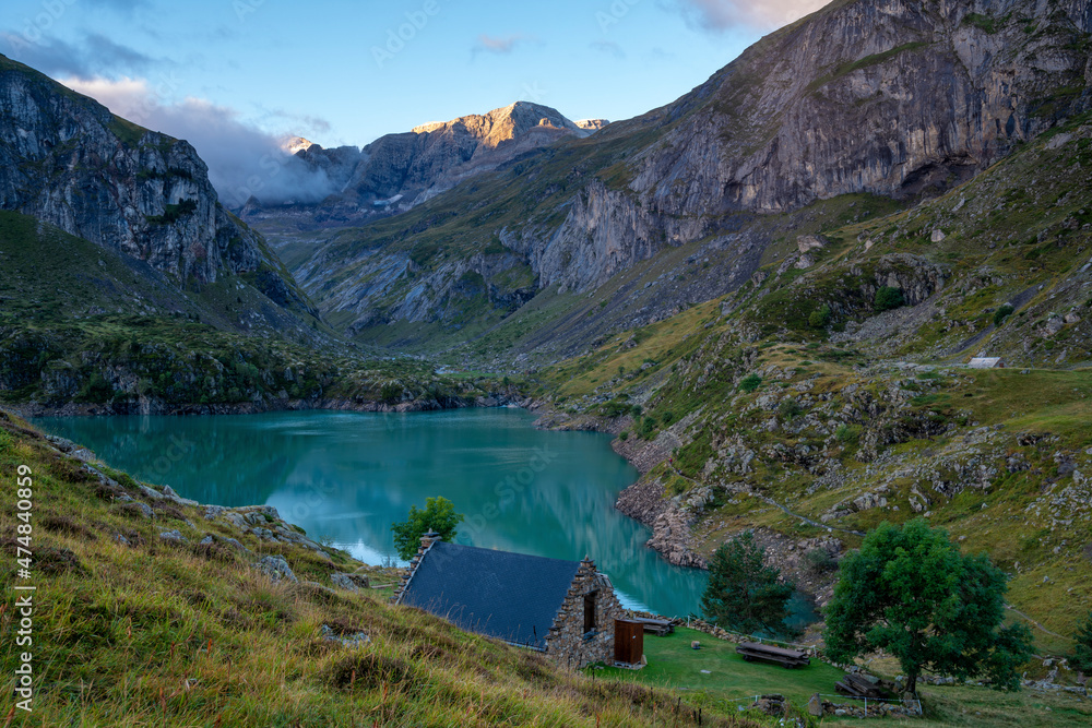 Fototapeta premium Mountain shelter from stone on a mountain lake in the Pyrenees of Lac des Gloriettes - France