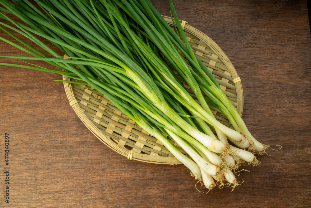 Fresh spring onion in bamboo basket on wooden background. Fresh spring onion in bamboo basket on wooden background.