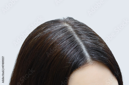 Gray hair on the crown of Caucasian woman close-up.