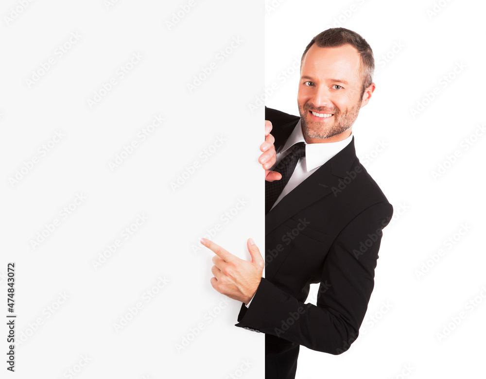 Smiling businessman pointing at blank sign Smiling businessman pointing at blank sign