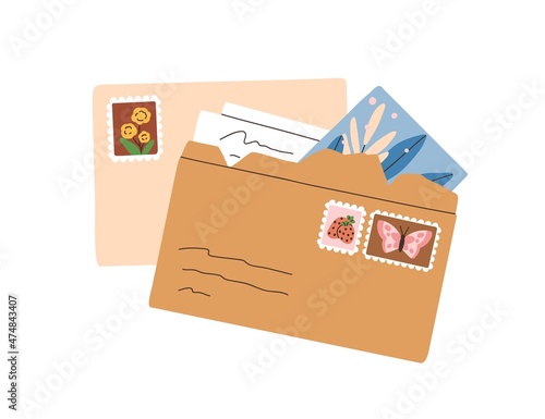 Open craft envelope with postage stamps, paper letter and post card. Handwrit...