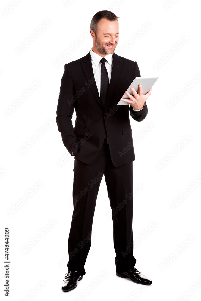 Full lenght of a standing businessman using digital tablet isolated on white.