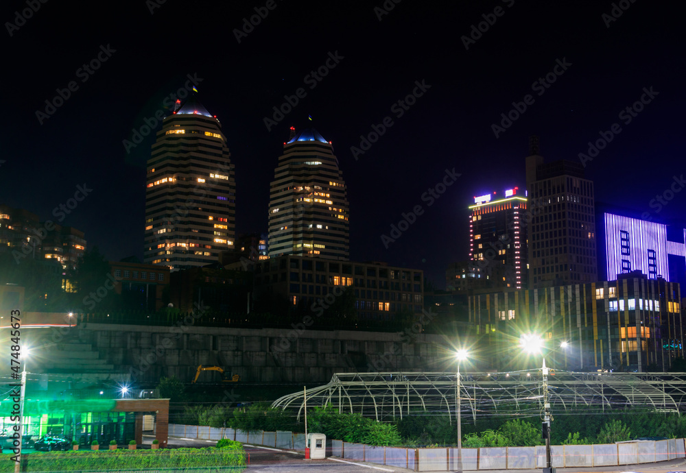 View of beautiful modern buildings, skyscrapers and towers of the night big city in Dnipro, Ukraine
