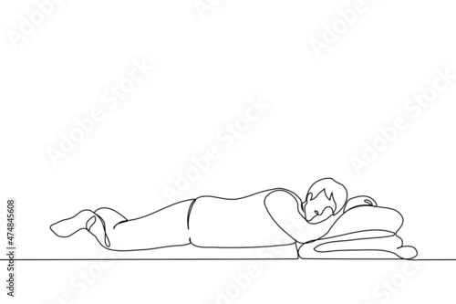 man is lying on bed with stomach down, he is sleeping on own hand - one line drawing vector. concept of sleep, dozing, relaxation