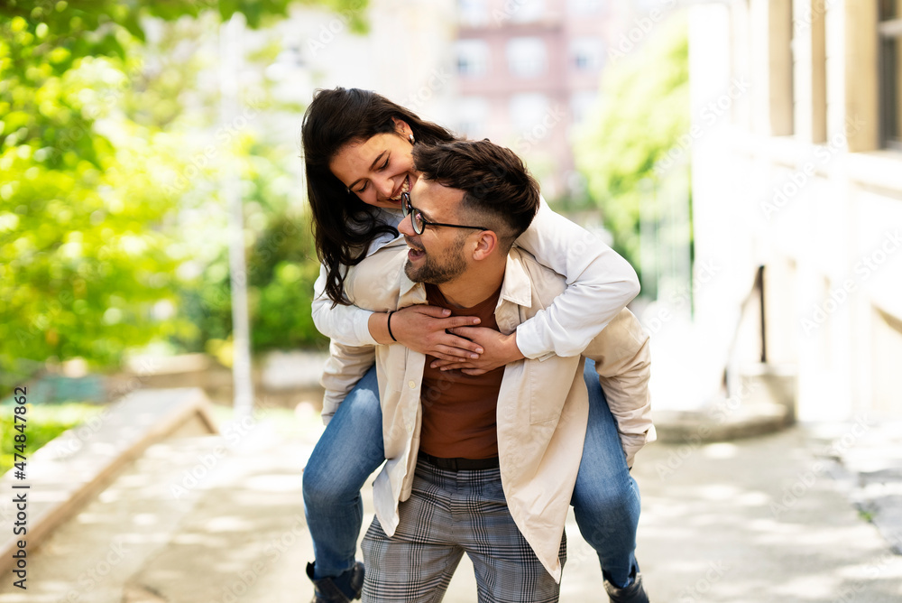 Happy young couple outdoors. Loving couple walking in the city. Happy young couple outdoors. Loving couple walking in the city.