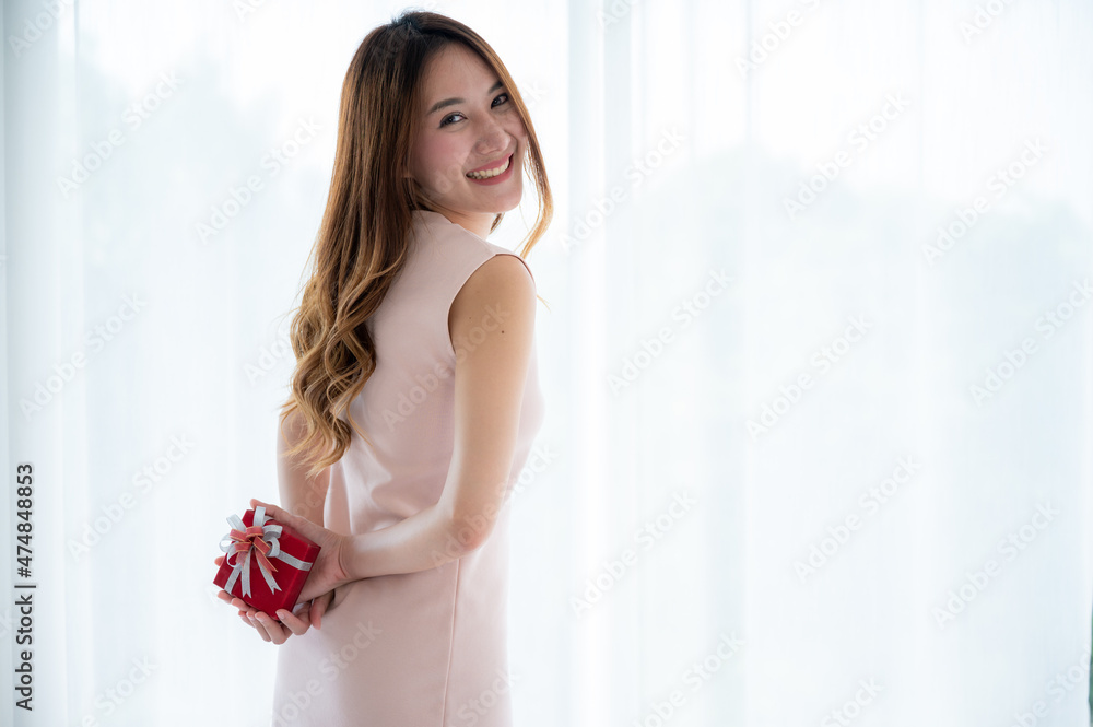 Christmas gift box concept, young Asian woman are happy and smile with a surprise gift present Christmas gift box concept, young Asian woman are happy and smile with a surprise gift present