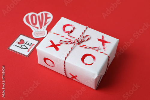 Valentine's Day concept with tic tac toe on gift box on red background photo