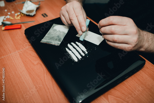 Drug addict. Drug abuse, man taking drugs, snorting lines of cocaine white powder, closeup. photo