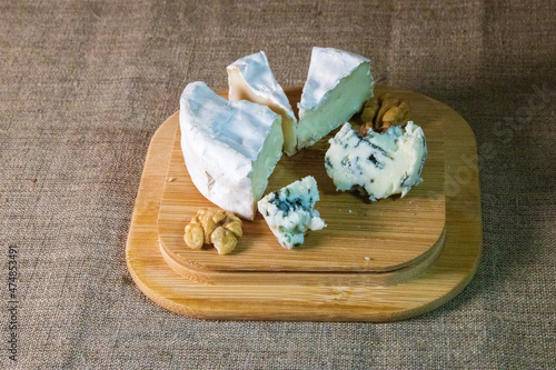 Cheese and nuts on a wooden plate