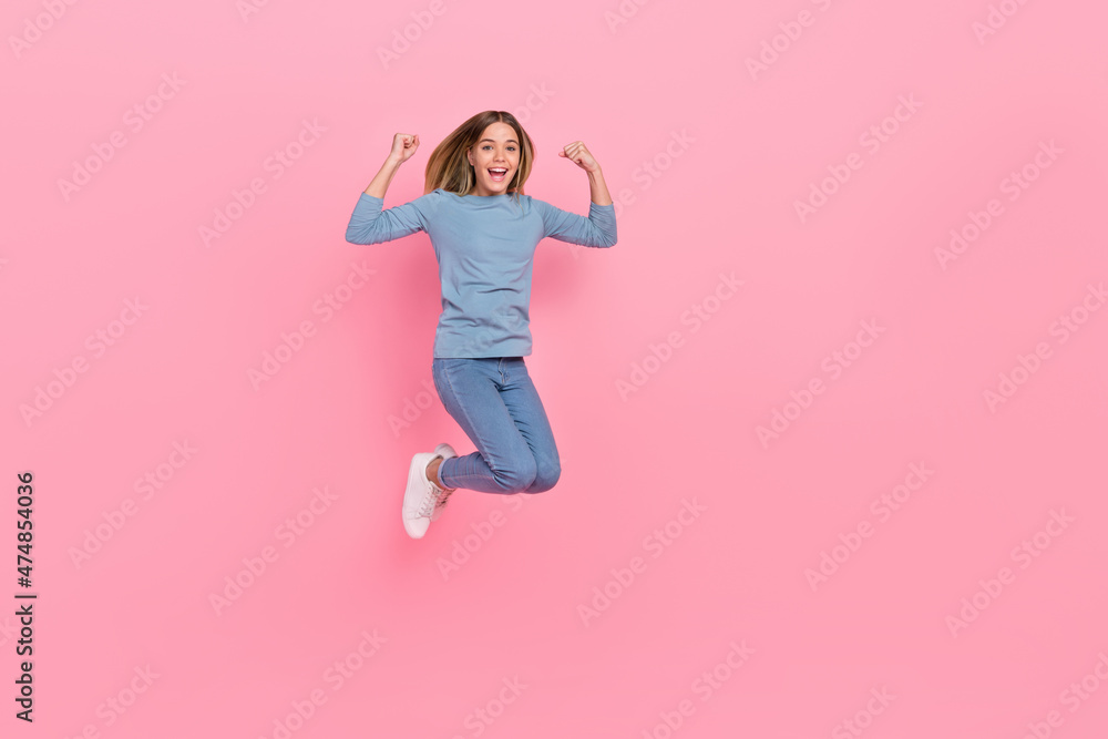Full length photo of young excited girl celebrate success fists hands triumph jump isolated over pink color background Full length photo of young excited girl celebrate success fists hands triumph jump isolated over pink color background