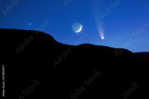 Crescent Moon, comet and stars above mountain silhouette. © astrosystem