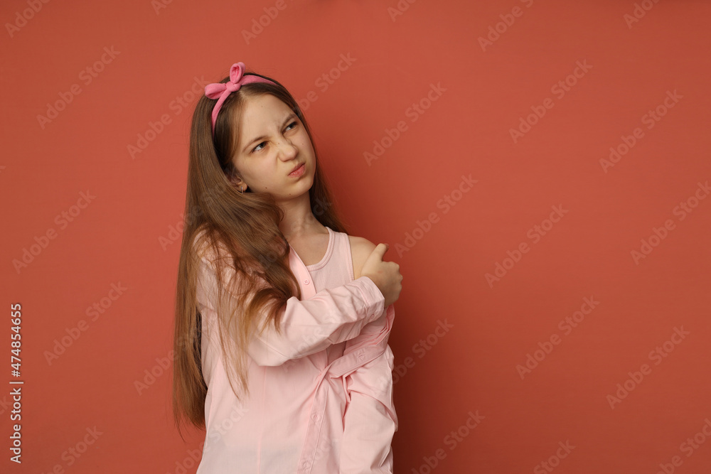 Fototapeta premium A teenage girl with a patch on her arm after vaccination. The girl frowns. Space for text, vaccination concept. High-quality photography