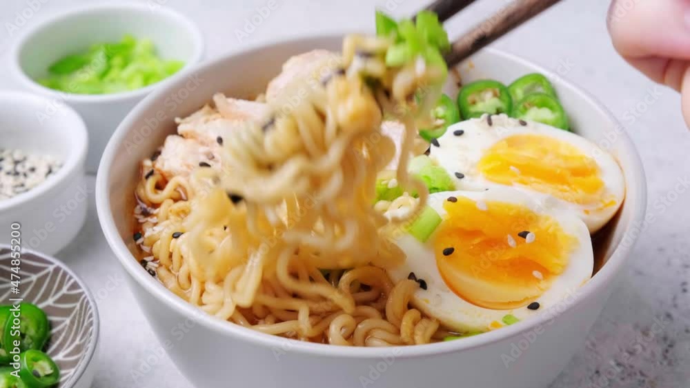 Eating asian noodle soup ramen with chicken and egg in gray bowl. Japanese food concept. Eating asian noodle soup ramen with chicken and egg in gray bowl. Japanese food concept.