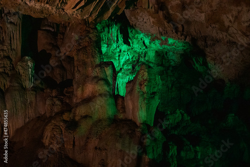 dark bright green abstract background of stalactites, stalagmites and stalagnates in the Sfendoni cave, underground, horizontal