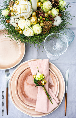 Festive luxury Christmas place setting on a table with a candle centrepiece