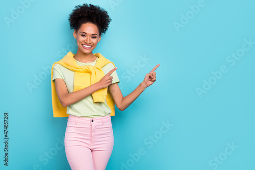 Photo of young african girl indicate fingers empty space advertise suggest direct promo isolated over blue color background