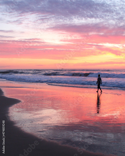 pessoa caminhando na beira do mar durante nascer do sol  © carina furlanetto