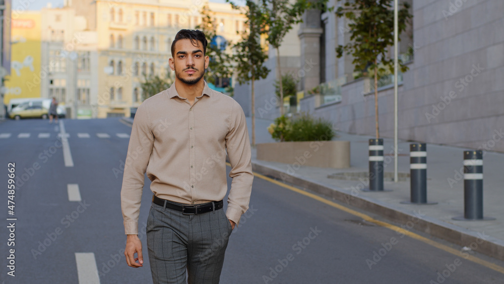 Successful happy handsome hispanic business man smiling arab guy boss worker arabian male manager man tourist in formal clothes walking in street in new old city going moving on road smile toothy