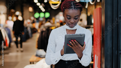 Φωτογραφία African american serious successful salesperson woman consultant in clothing sto