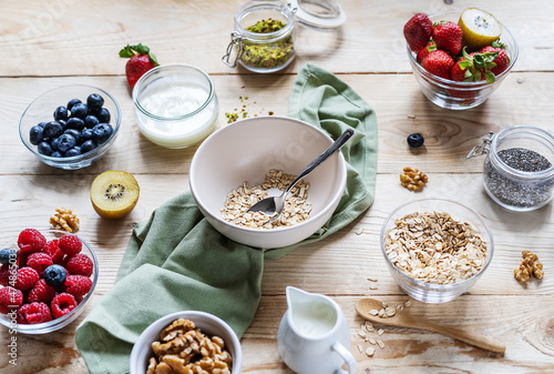 Healthy breakfast concept with oat flakes, fruits, yogurt, nuts, berries, chia seeds