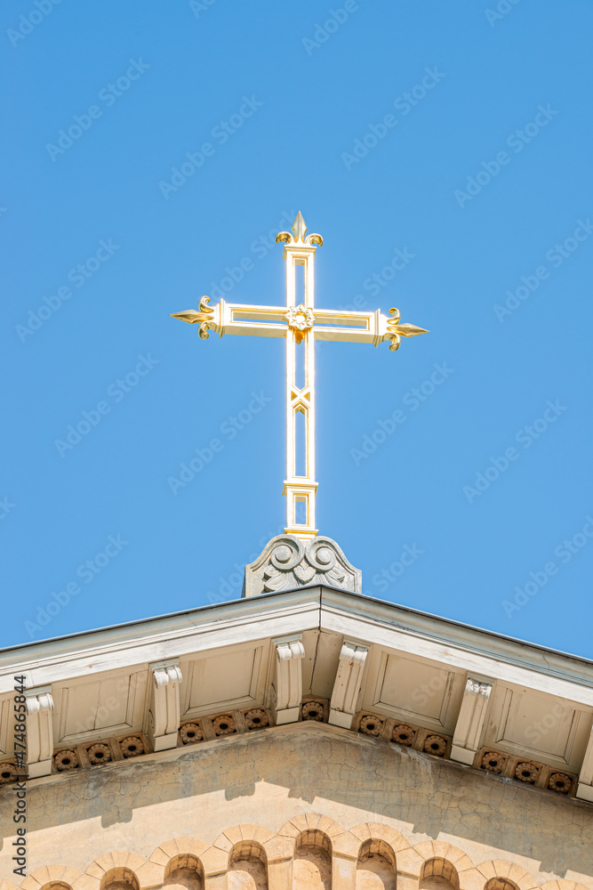 Ancient monastery golden cross at blue sky solid background with copy space. Concept of religious and historic heritage. Ancient monastery golden cross at blue sky solid background with copy space. Concept of religious and historic heritage.