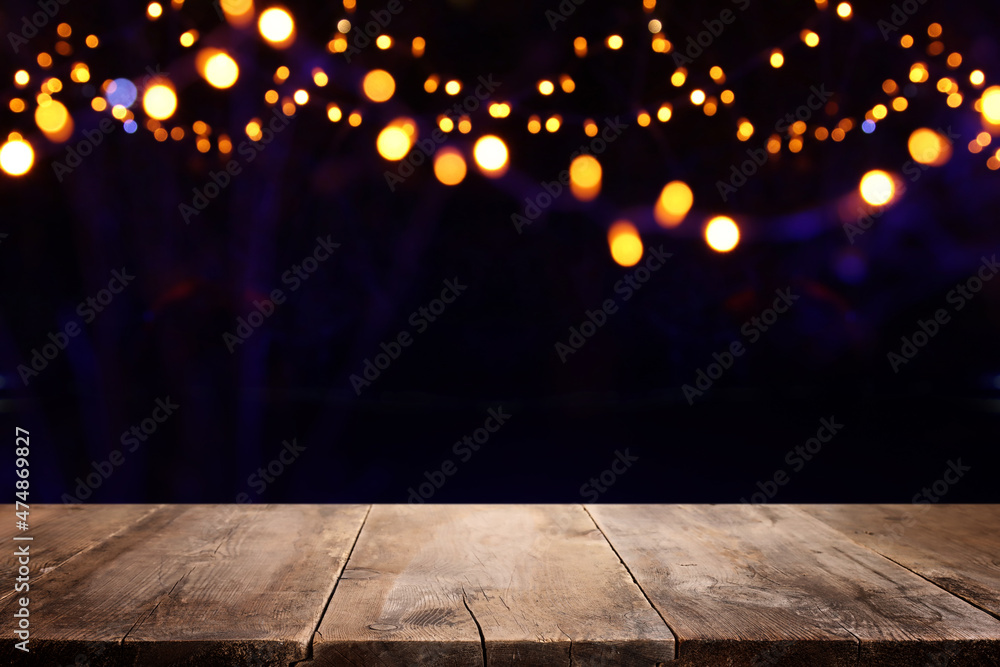 background Image of wooden table in front of abstract blurred lights background Image of wooden table in front of abstract blurred lights