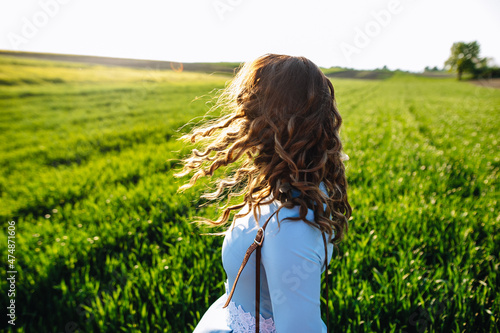 Foto Young woman standing on street with hair blown by the wind, covering her face