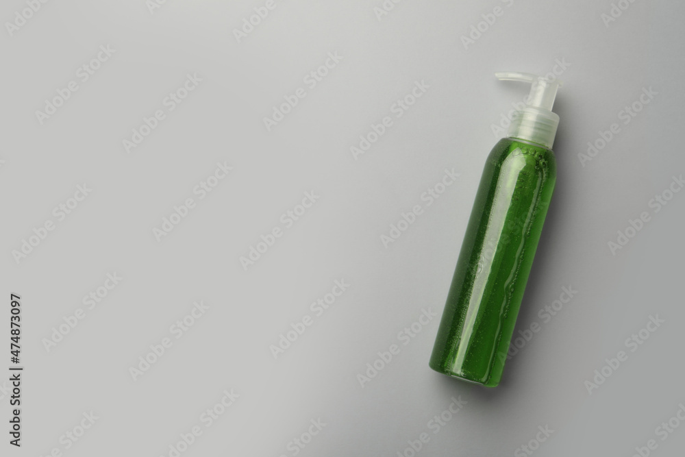 Bottle of green cosmetic gel on light background, top view. Space for text Bottle of green cosmetic gel on light background, top view. Space for text