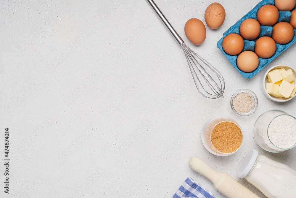 Variety of ingredients and baking utensils on white background. Kitchen background with copy space Variety of ingredients and baking utensils on white background. Kitchen background with copy space