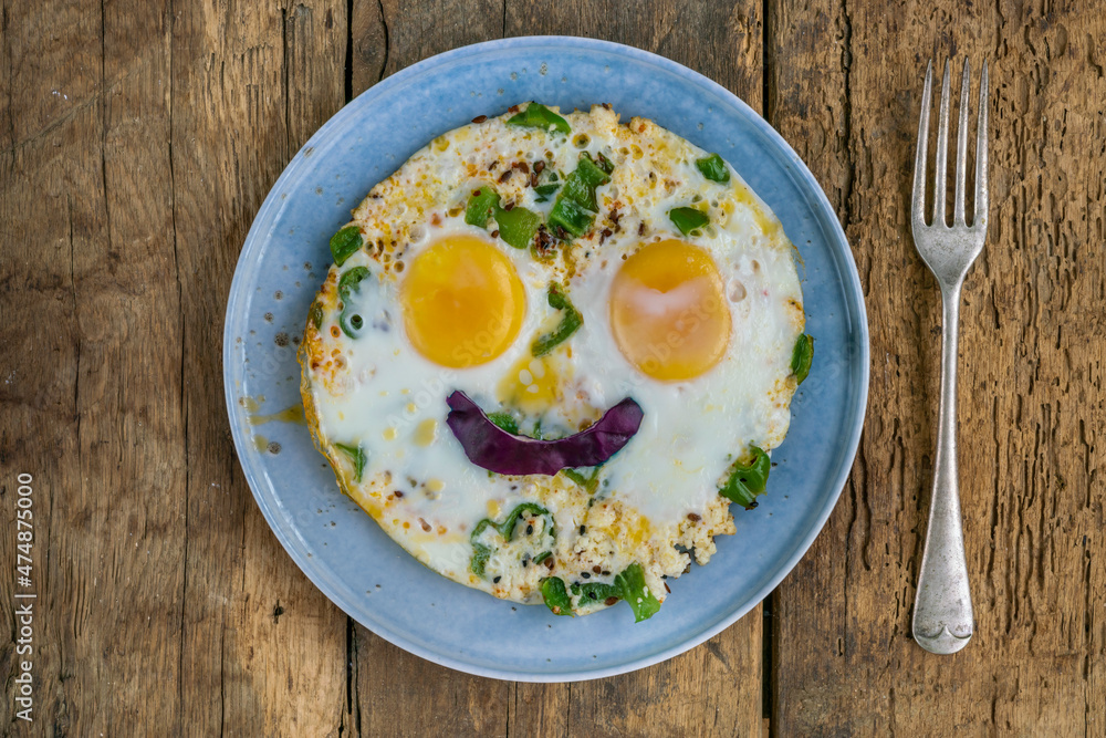 fried eggs with smiling face shape on wooden table for breakfast fried eggs with smiling face shape on wooden table for breakfast