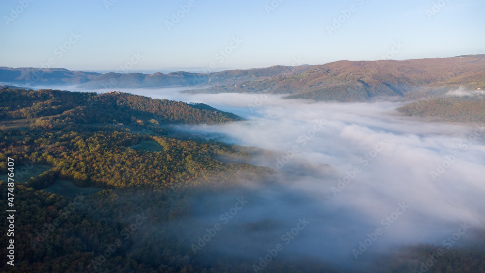 Drone shot of the landscape in Umbria in Italy. Sunrise with fog in the valley. High quality photo
