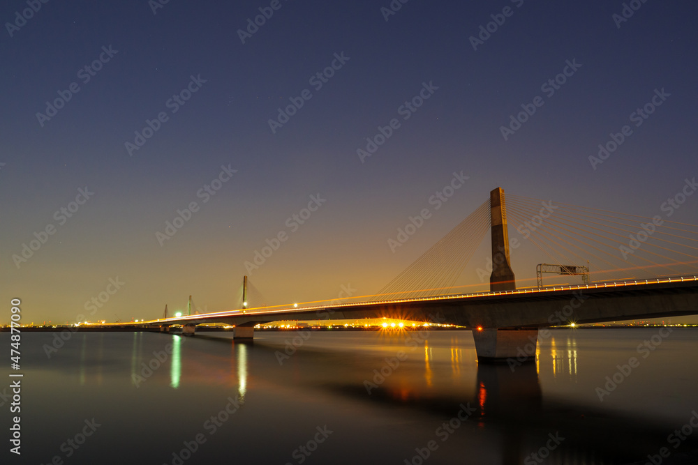 夜の湾岸木曽川橋を渡るトラックの光跡
